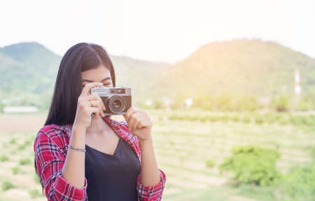 Young hipster woman photographer holding a vintage camera.