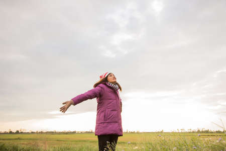 Young woman was playing in a field of flowers in the winter air.の写真素材