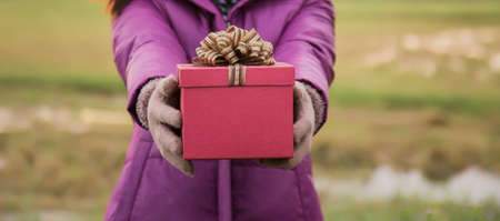 Happy young woman with gift in hands. Christmas and winter concept.の写真素材