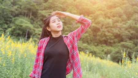 Young beautiful woman standing in the flower field enjoyment.の写真素材