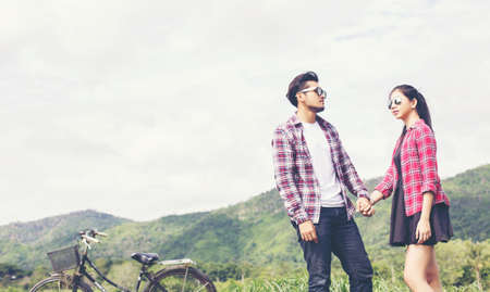 Young hipster couple holding hands walking on the meadow relaxing and natural atmosphere is very natural.の写真素材
