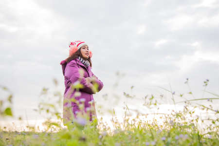 Young woman was playing in a field of flowers in the winter air.の写真素材