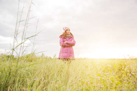 Young woman was playing in a field of flowers in the winter air.の写真素材