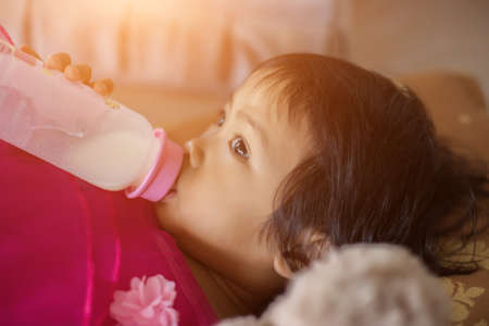 happy little girl in cap playing with Teddy bear in summer Parkの写真素材