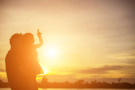 Father took the baby learn to walk at sunset.の写真素材