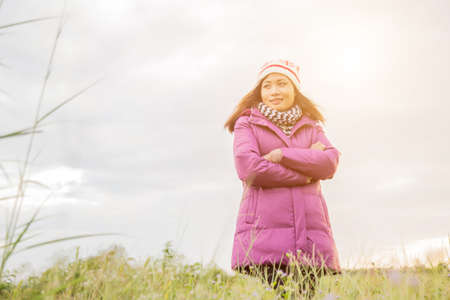 Young woman was playing in a field of flowers in the winter air.の写真素材