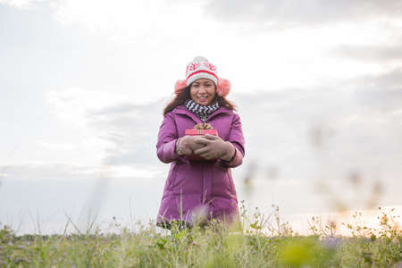 Happy young woman with gift in hands. Christmas and winter concept.