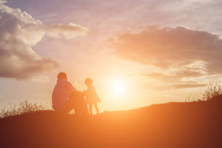 father and son having fun on sunsetの写真素材