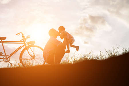father and son having fun on sunsetの写真素材