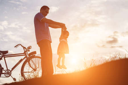 father and son having fun on sunsetの写真素材