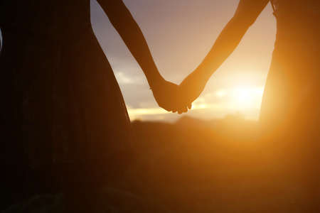 young couple holding hands. In Nature sunriseの写真素材