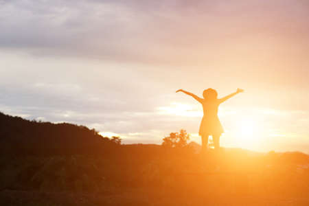 Silhouette of woman praying over beautiful sky backgroundの写真素材