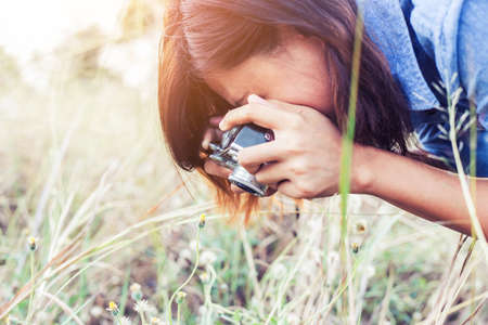 Vintage of beautiful women photography standing hand holding retro camera with sunrise,dream soft...