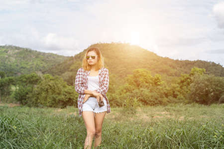 Vintage of beautiful women photography standing hand holding retro camera with sunrise,dream soft styleの写真素材