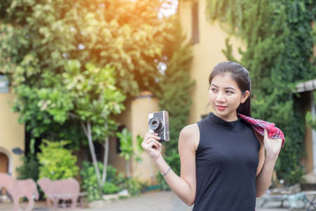 Young beautiful woman with retro camera , Vintage retro style Asian girl on vacation smiling happy.の写真素材