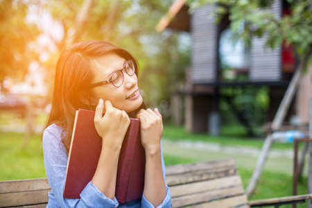 A woman sitting in the garden reading a book.
