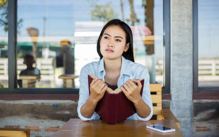 Hipster charming girl relaxing in the park while read book, Enjoy nature around.の写真素材