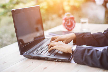 Hands of Businessman working on Laptop Computer with Data Chartsの写真素材