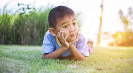 Happy mulatto boy child is smiling enjoying adopted life. Portrait of young boy in nature, park or outdoors. Concept of happy family or successful adoption or parenting.の写真素材