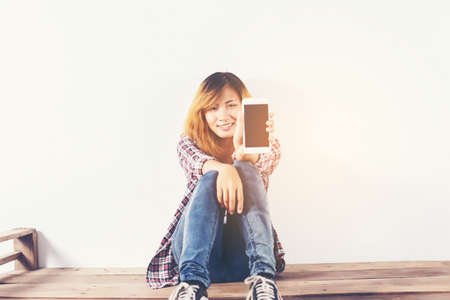 Close-up of a woman typing on mobile phone isolated on white background,Woman's hand holding smartphone.の写真素材