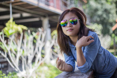 Portrait of young hipster woman relaxing on a balcony on a sunny summer. Smiling enjoy with nature.の写真素材