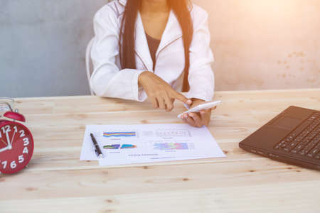 Hands of Businessman working on Laptop Computer with Data Chartsの写真素材