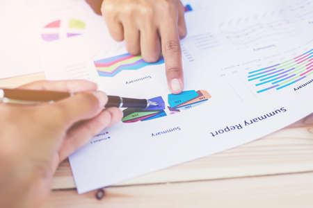Hands of Businessman working on Laptop Computer with Data Charts