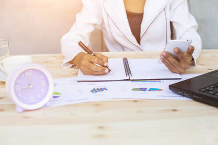 Hands of Businessman working on Laptop Computer with Data Chartsの写真素材