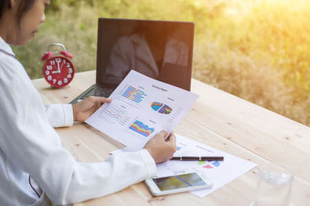 Hands of Businessman working on Laptop Computer with Data Chartsの写真素材