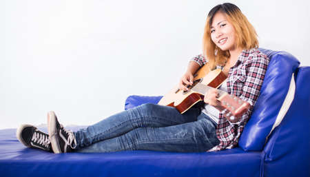 Young hipster woman playing a guitar.の写真素材