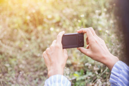 little girl photographs flower outdoorの写真素材