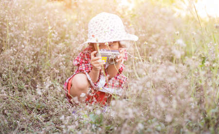 little girl photographs flower outdoorの写真素材