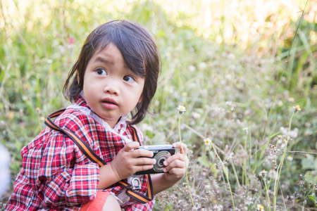little girl photographs flower outdoorの写真素材