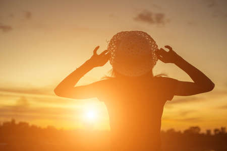 Silhouette of woman praying over beautiful sky backgroundの写真素材