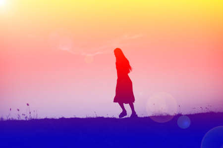 silhouette of a young woman standing alone