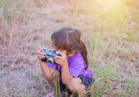 Woman with camera hiding behind the treeの写真素材