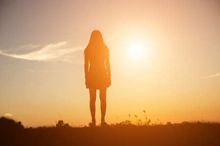 Silhouette of woman praying over beautiful sky backgroundの写真素材