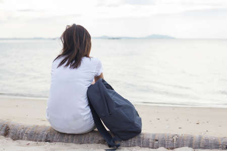 Sad lonely beautiful woman sitting on the pierの写真素材