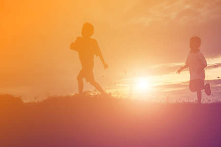 silhouette of a happy children and happy time sunsetの写真素材