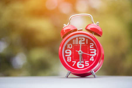 6 o'clock Clock Vintage on Wood Table with Sun Light