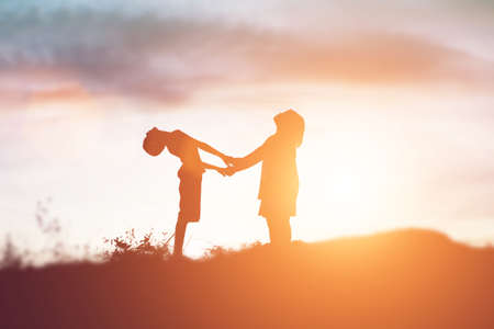 silhouette of a happy children and happy time sunsetの写真素材