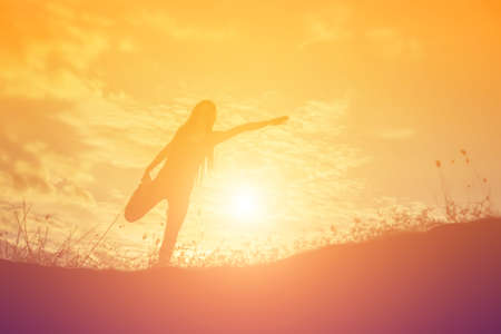 silhouette of a young woman standing aloneの写真素材