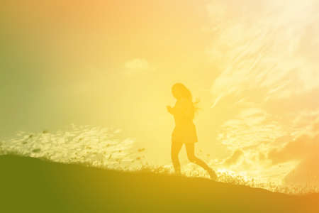 silhouette of a young woman standing aloneの写真素材