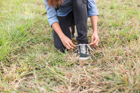 Hands of a young woman lacing sneakersの写真素材