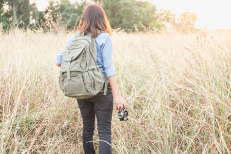 Woman photographed in a meadow with a camera.の写真素材