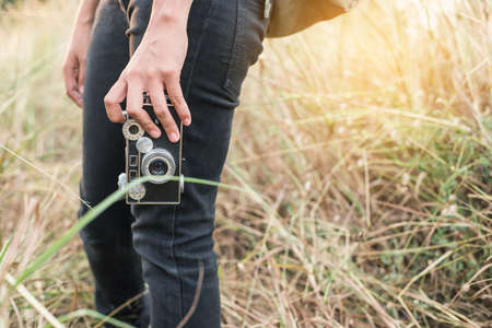 Woman photographed in a meadow with a camera.の写真素材