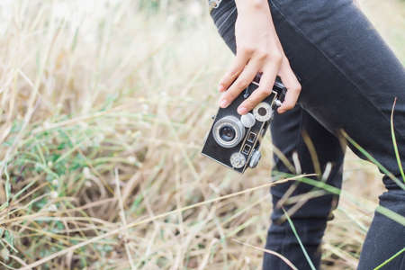 Woman photographed in a meadow with a camera.の写真素材