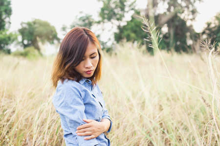 Woman photographed in a meadow with a camera.の写真素材