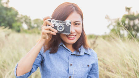 Woman photographed in a meadow with a camera.の写真素材