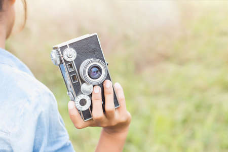 Woman photographed in a meadow with a camera.の写真素材